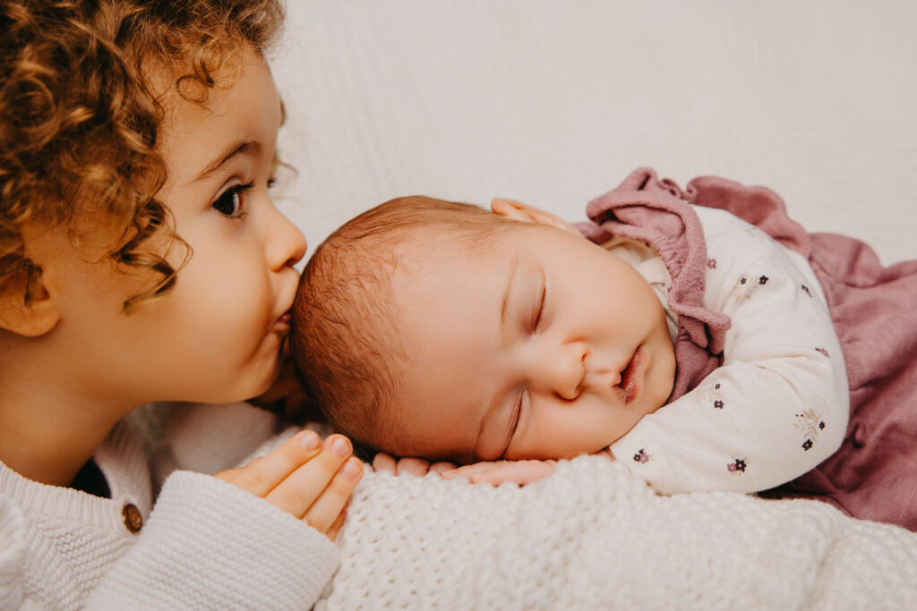 Schwester küsst Baby
